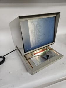 Vintage microfilm reader with screen and controls.