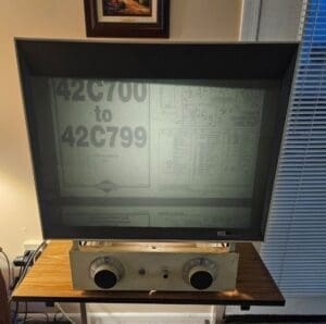 Vintage microfilm reader on wooden table.