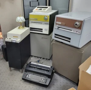 Vintage computers and office equipment in room.